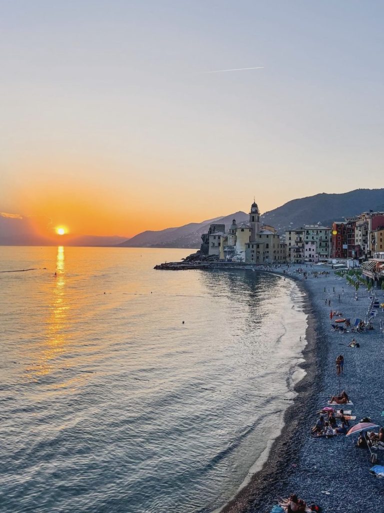 Case pastello di Camogli al tramonto con barche in primo piano
