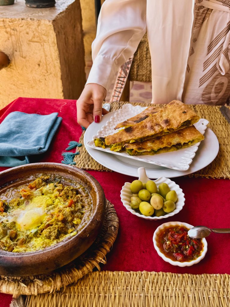 Tajine di pollo al limone servito in piatto di terracotta