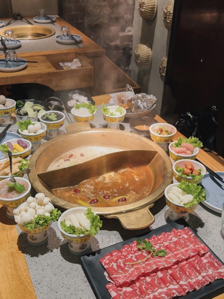 Pentola dell'hot pot con brodo caldo al centro del tavolo