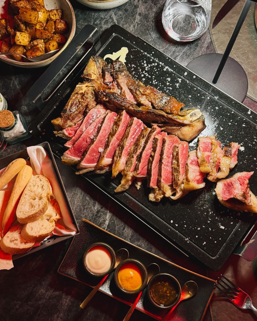 Costata T-Bone al tavolo, taglio e sezione rosa all'interno