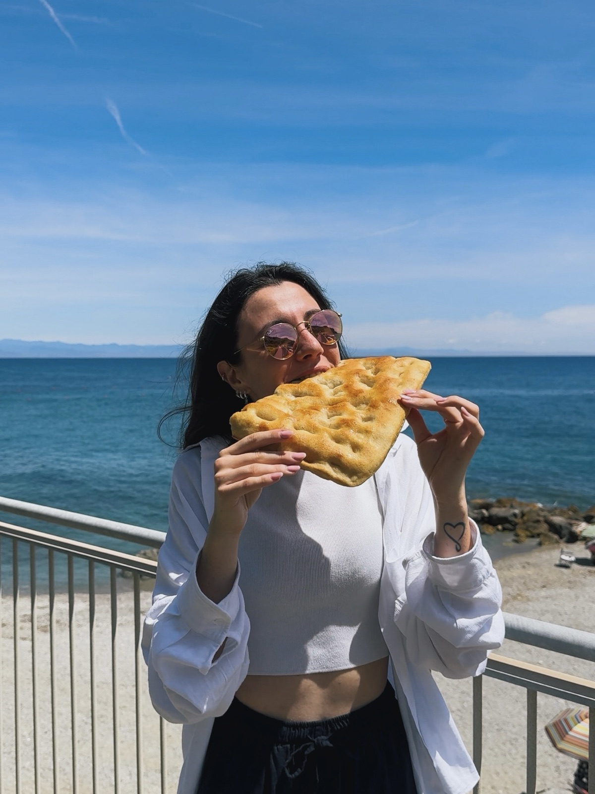 Ludo che mangia la focaccia ligure vista mare