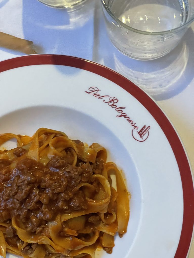 Sala interna di Dal Bolognese con divanetti rossi e tavoli rotondi