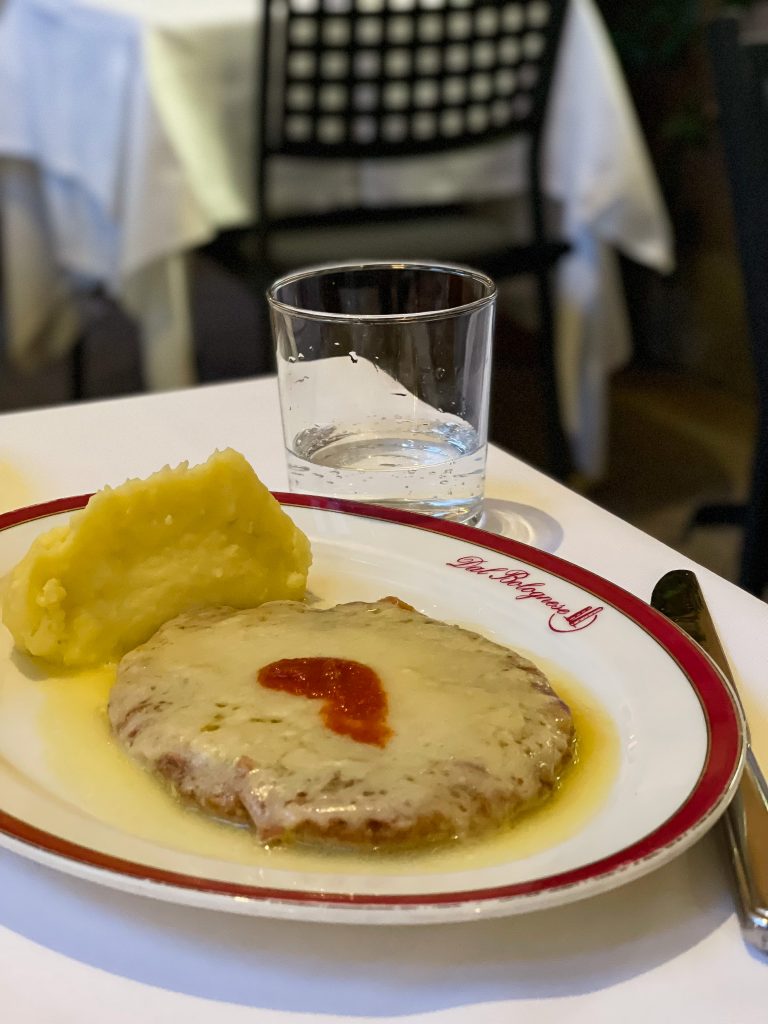 Cotoletta alla bolognese impiattata con cura, piatto forte del menu
