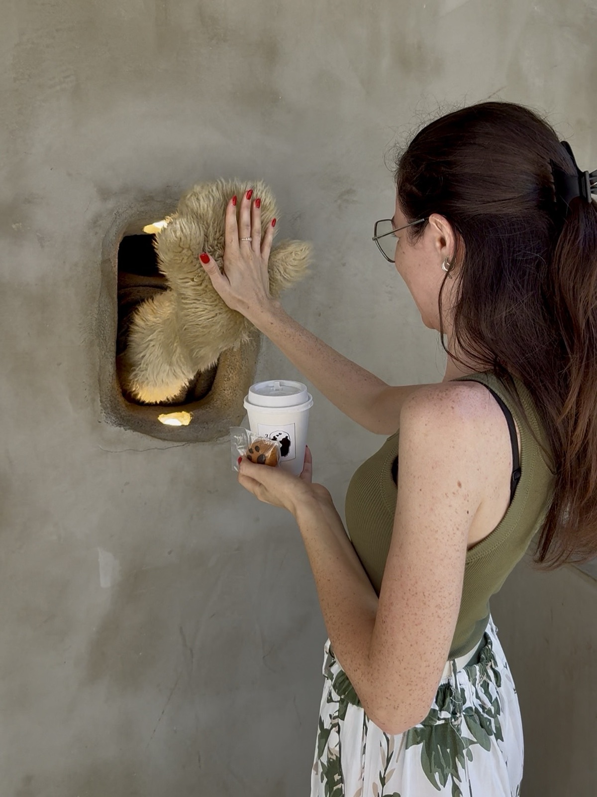 Bear Paw Café a Osaka, zampina di orsetto che consegna l'ordine attraverso un buco nel muro
