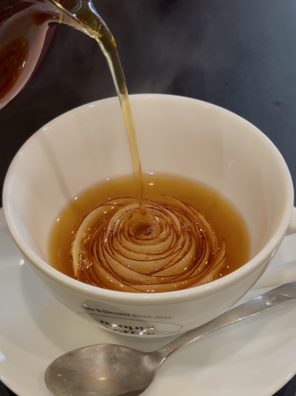 Oyoppi Café a Tokyo, tè con mela scolpita a forma di rosa che si apre con l'infusione