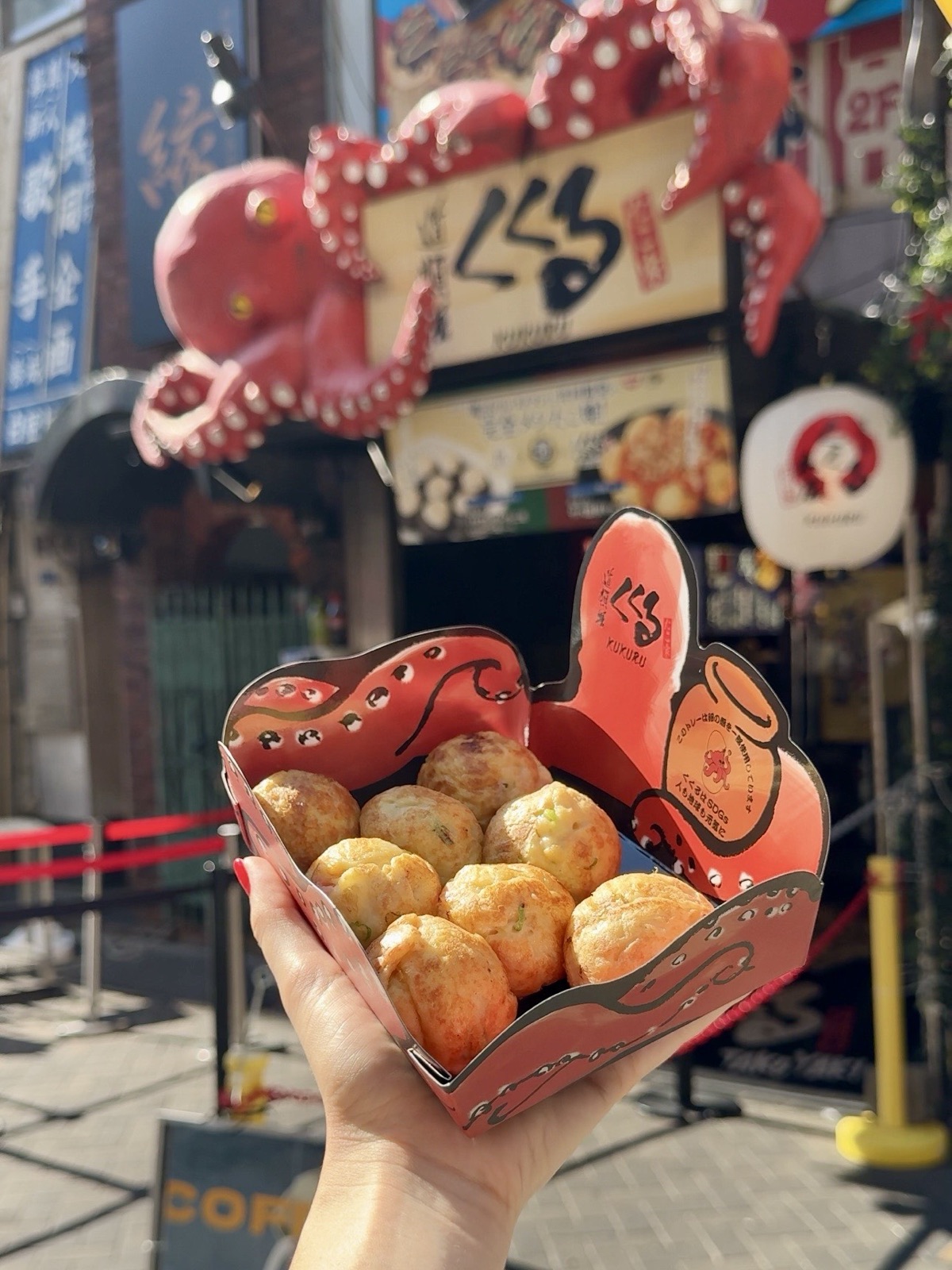 Takoyaki di Kukuru a Dotonbori, Osaka, polpette di pastella con polpo ricoperte di salsa