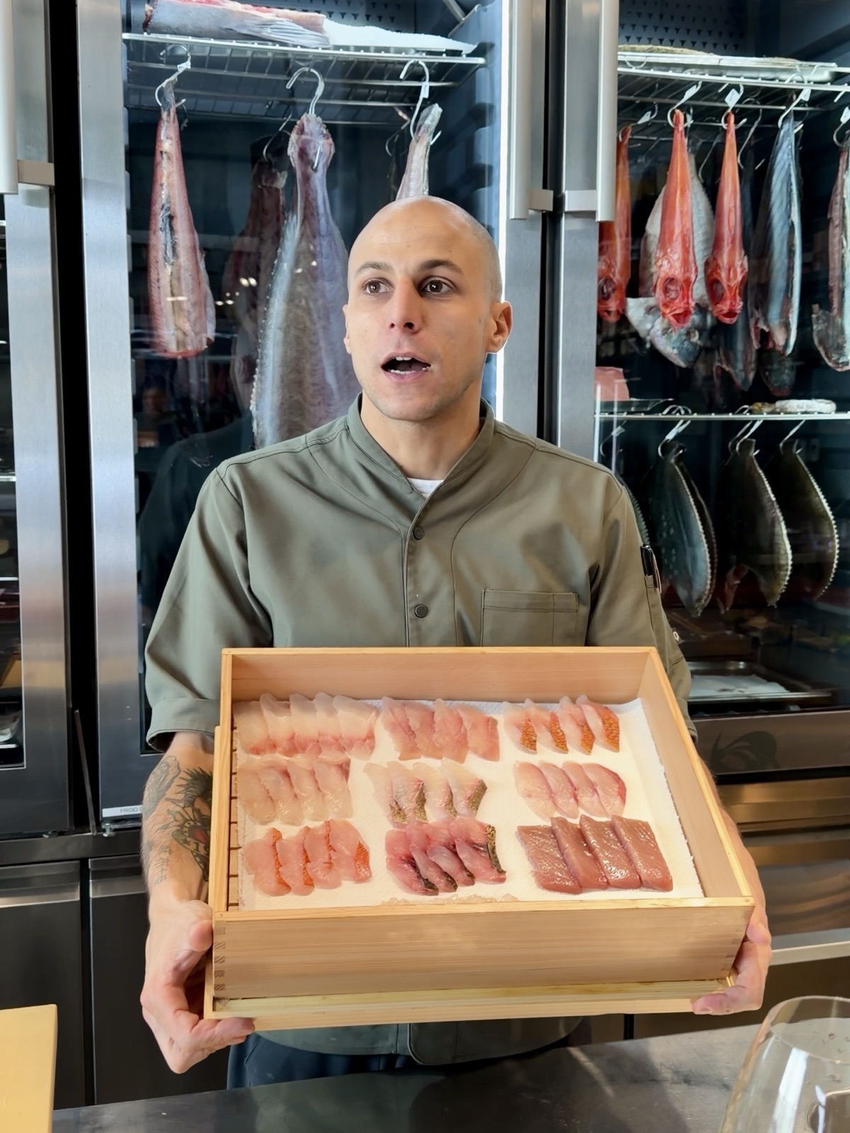 Chef di Azabu10 con la cassetta del pesce frollato usato per l'omakase a Milano