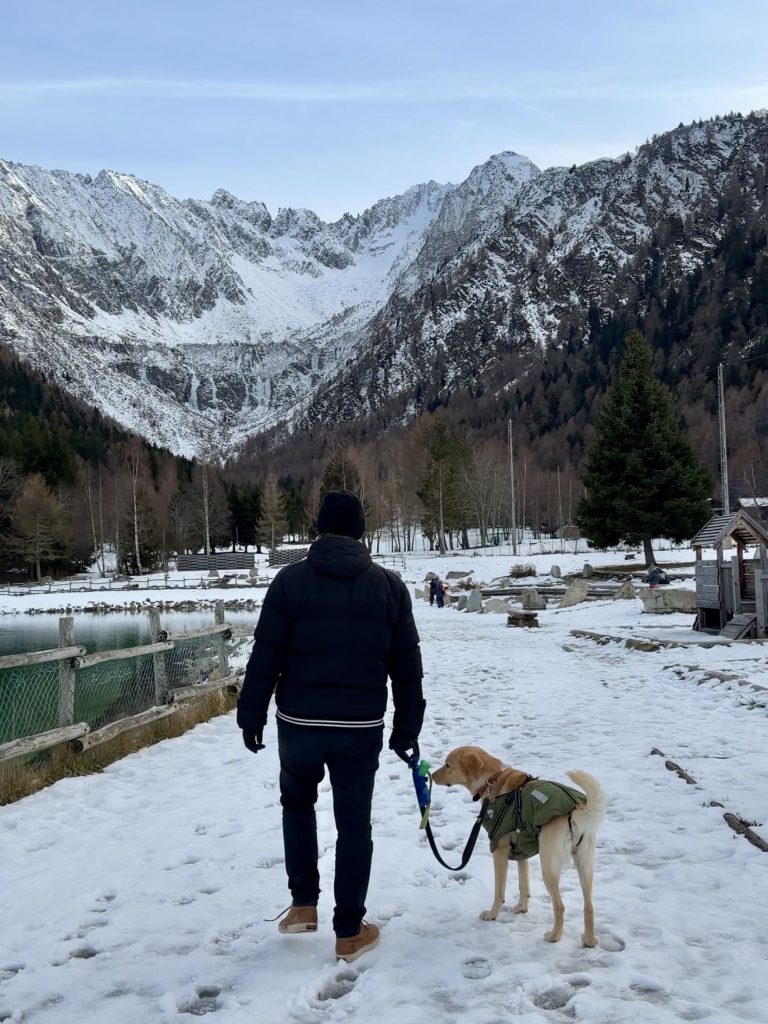 Ludovica con Simba in mezzo alla neve, vista sulle montagne di Ponte di Legno