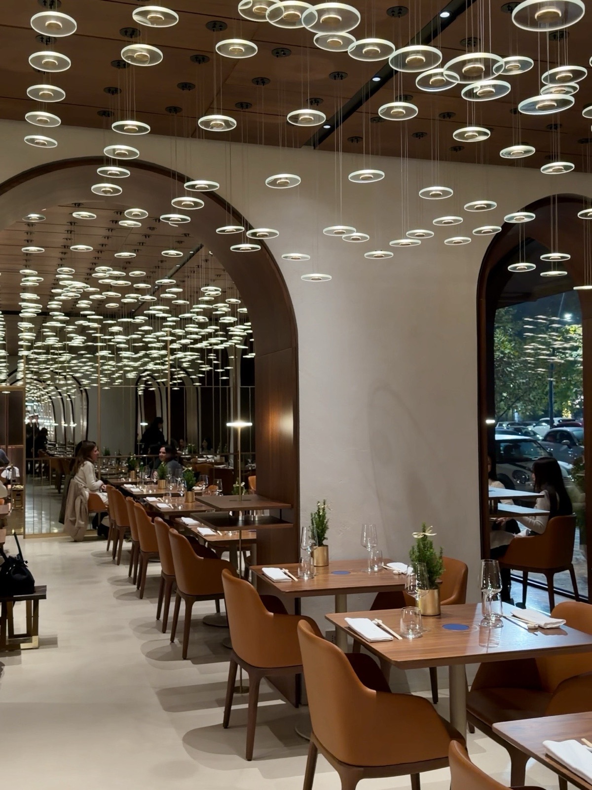 Sala interna del ristorante Izu a Milano con i punti luce sospesi al soffitto e gli archi