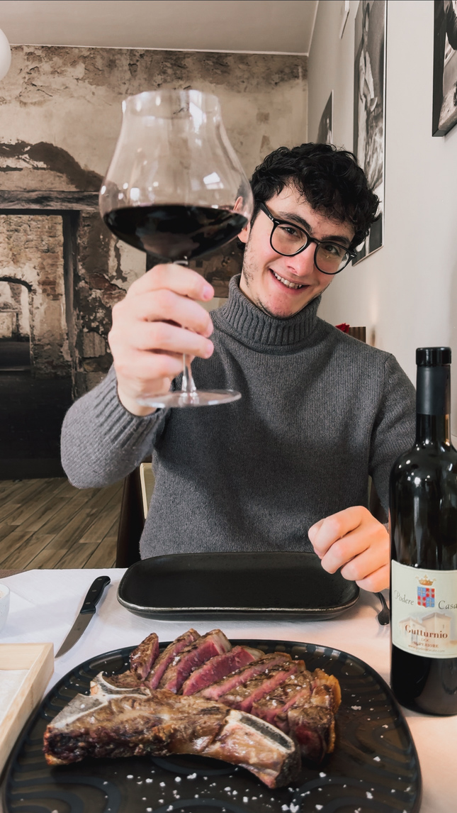 Brindisi con calice di vino rosso all'Antica Macelleria Turba