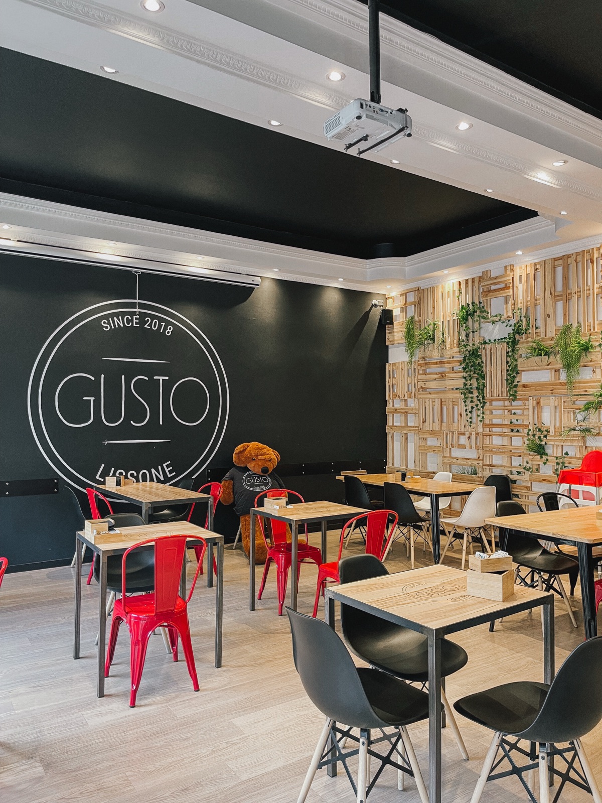 Sala interna di Gusto a Lissone con tavoli e altalene