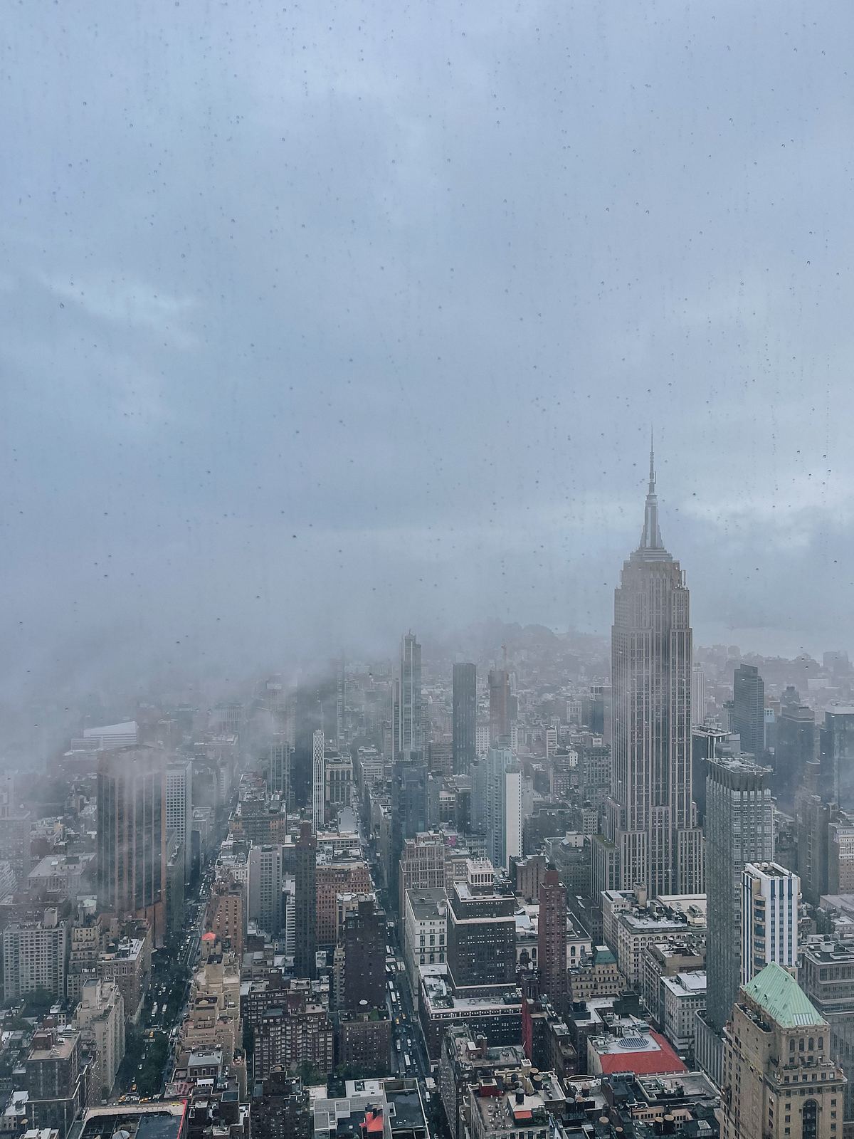 Vista su Manhattan e sull'Empire State Building dalle vetrate del SUMMIT One Vanderbilt in una giornata di nebbia