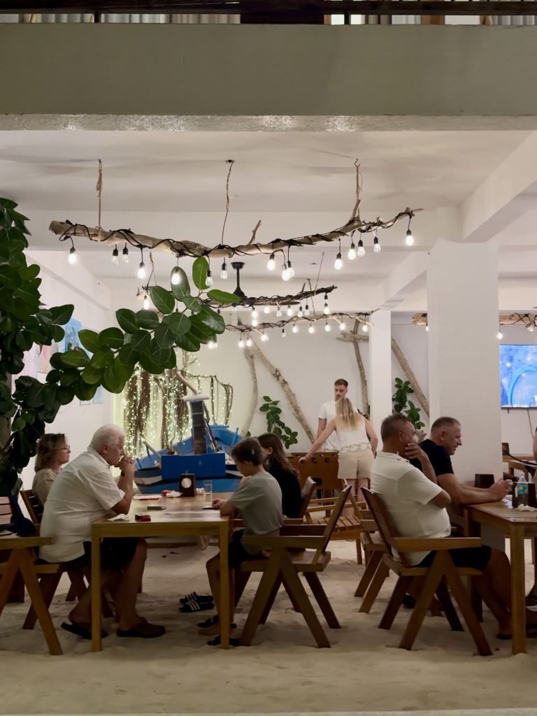 Zona comune della guesthouse con ospiti a cena