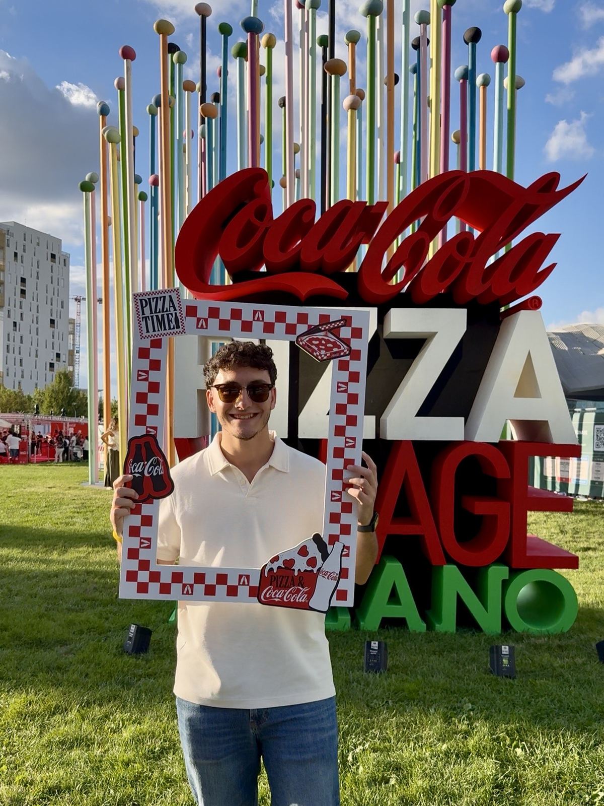 Gianmaria davanti alla scritta Coca-Cola Pizza Village al Parco di CityLife