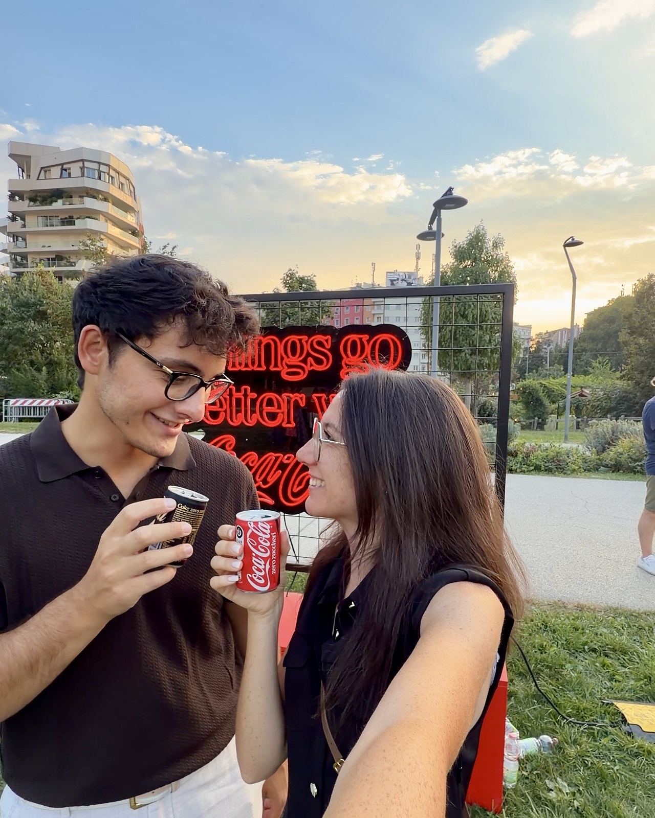 Ludovica e Gianmaria con una Coca-Cola in mano al tramonto, al Coca-Cola Pizza Village del Parco di CityLife a Milano