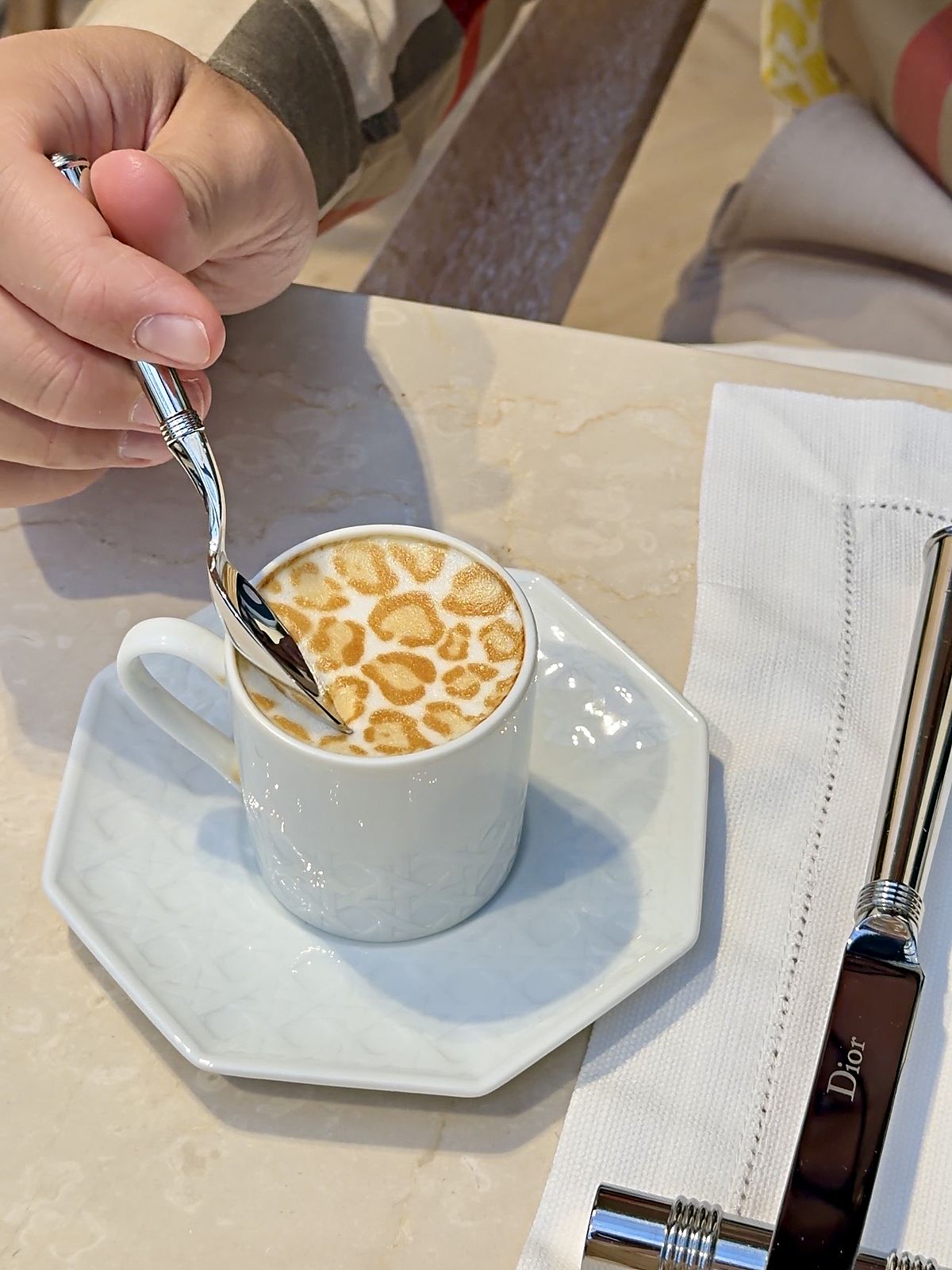 Caffè macchiato con la schiuma leopardata e il coltello Dior al ristorante Dior di Milano