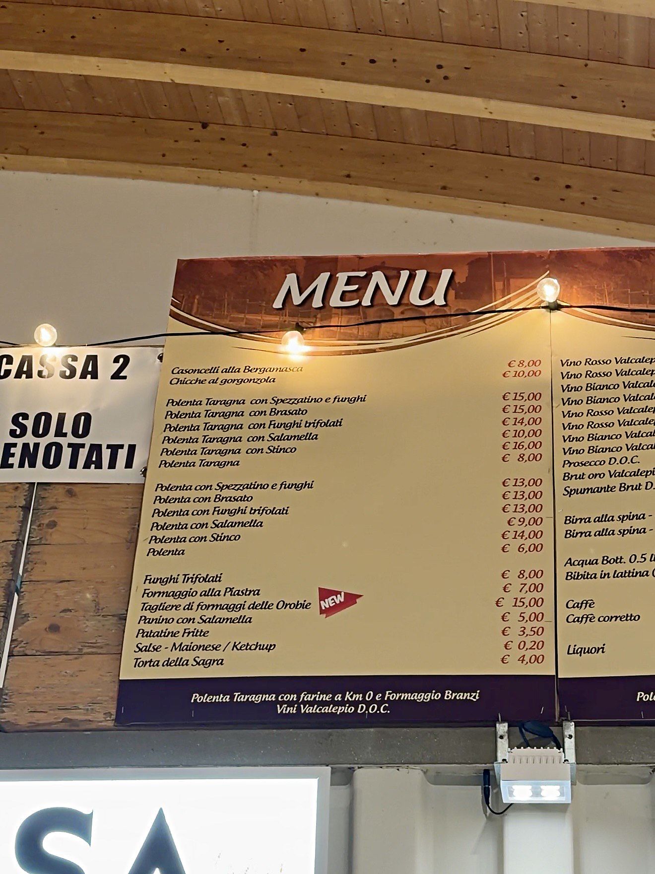 Il menù con i prezzi della Sagra della Polenta Taragna di Spirano 2026, appeso sopra le casse