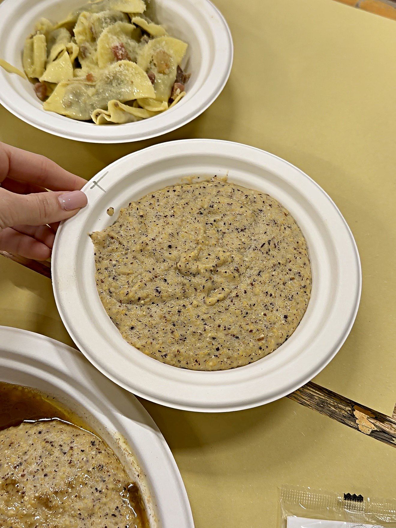 Un piatto di polenta taragna semplice accanto ai casoncelli alla bergamasca