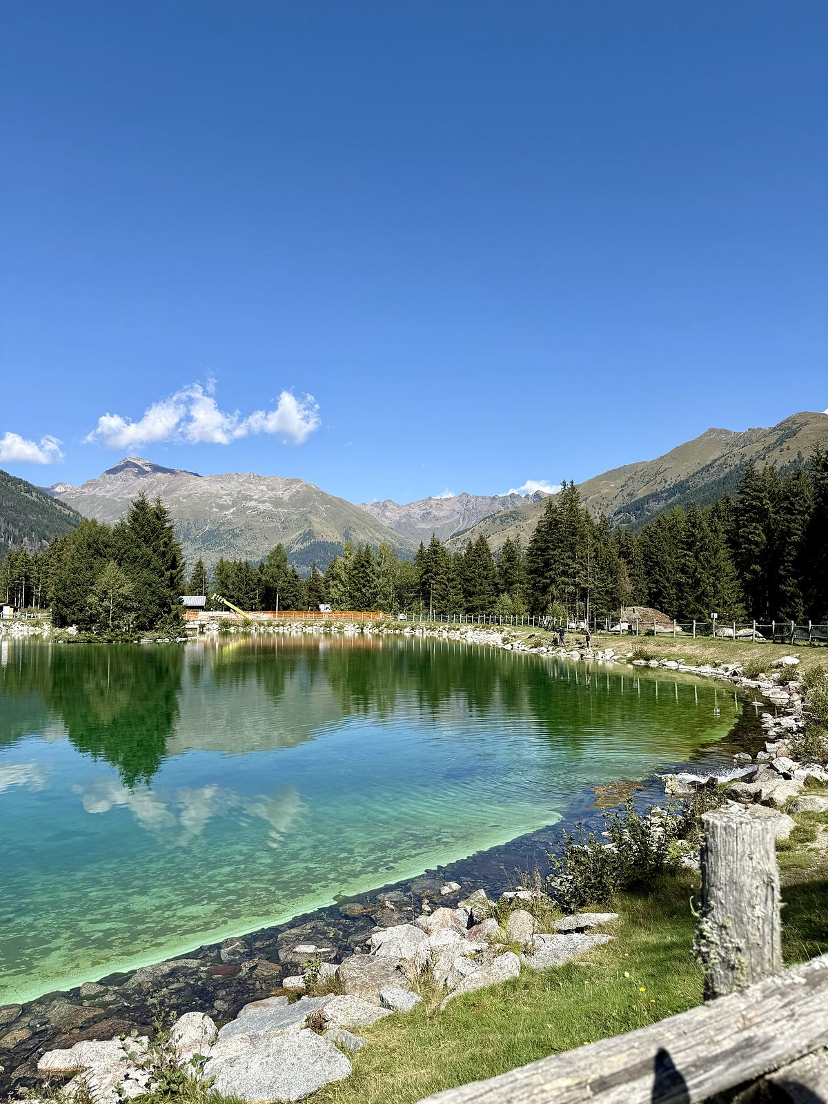 Lago di Valbione d'estate con acqua verde e turchese e le montagne riflesse