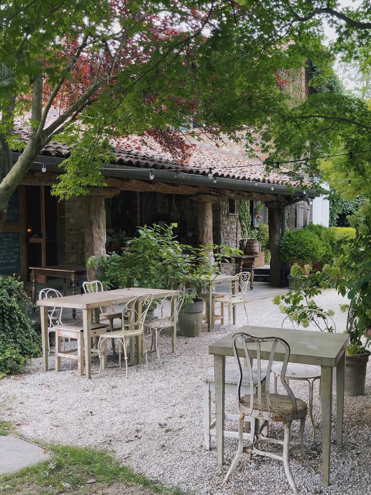 Tavoli e sedie vintage all'aperto del Càmp di Cent Pertigh, ex cascina nel verde di Carate Brianza
